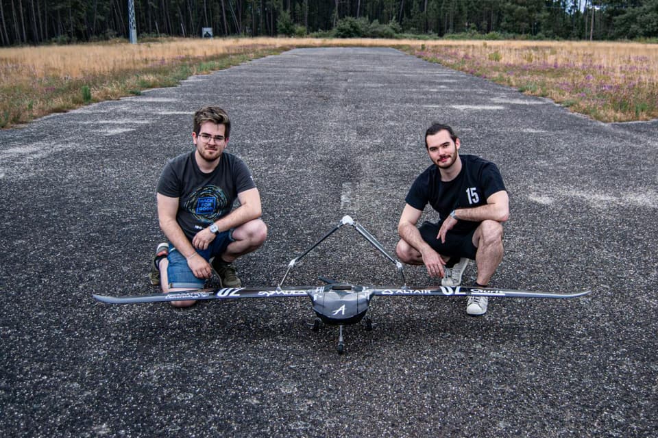 Pablo and a teammate crouch on a runway beside MIR-10, a carbon-fibre aircraft with an unusual configuration.